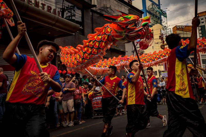MANILA, PHILIPPINES - FEBRUARY 10: Filipinos watch dragon dancers perform during Lunar New Year celebrations at Binondo district, considered the world's oldest Chinatown, on February 10, 2024 in Manila, Philippines. Lunar New Year, also known as Chinese New Year, is celebrated around the world, and the year of the Wood Dragon in 2024 is associated with growth, progress, and abundance, as wood represents vitality and creativity, while the dragon symbolizes success, intelligence, and honor.  (Photo by Ezra Acayan/Getty Images)