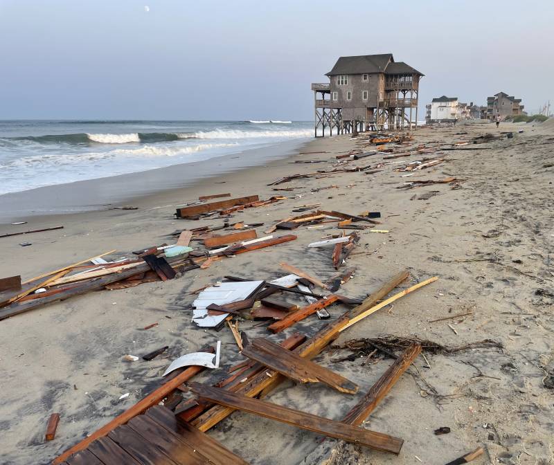 Debris from a house collapse on a beach.