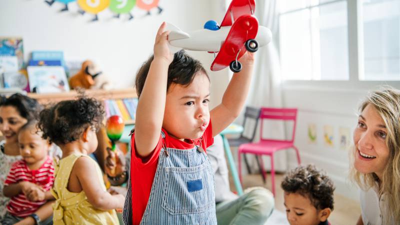 Preschooler enjoying playing with his airplane toy