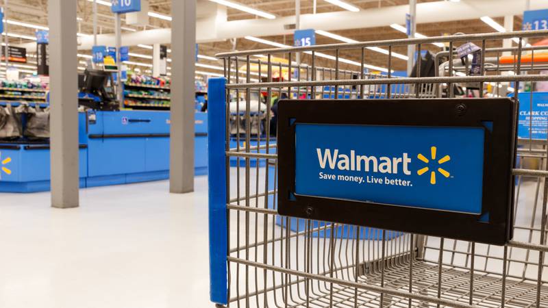 A shopping cart inside a Walmart store.