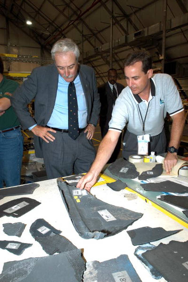 In this NASA handout, NASA Administrator Sean O'Keefe (L) and Shuttle Test Director Steve Altemus, a member of the Columbia Reconstruction Project Team look over pieces of debris from the Space Shuttle Columbia April 28, 2003 at the Kennedy Space Center, Floridia. More than 70,000 items have been delivered to the space center in the ongoing mishap investigation.  (Photo by NASA/Getty Images) (NASA HANDOUT)