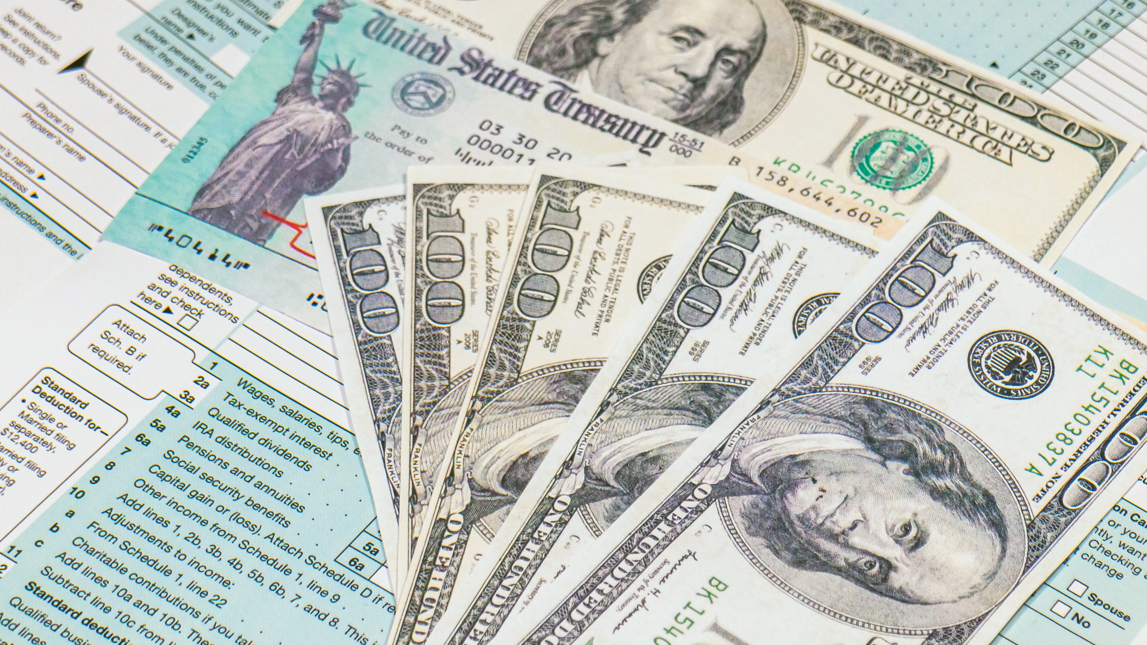 Stimulus economic tax return check and and 1040 Form with dollars.