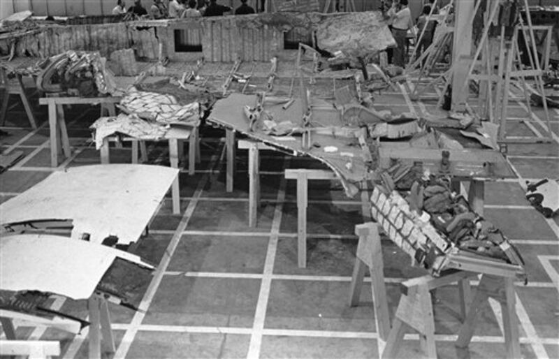 The right wing of the space shuttle Challenger as it lies in a warehouse on the Kennedy Space Center on Wednesday, April 9, 1986. Shown in the background are representatives of the media who were allowed to view the wreckage for the first time. (AP Photo/Burce Weaver)