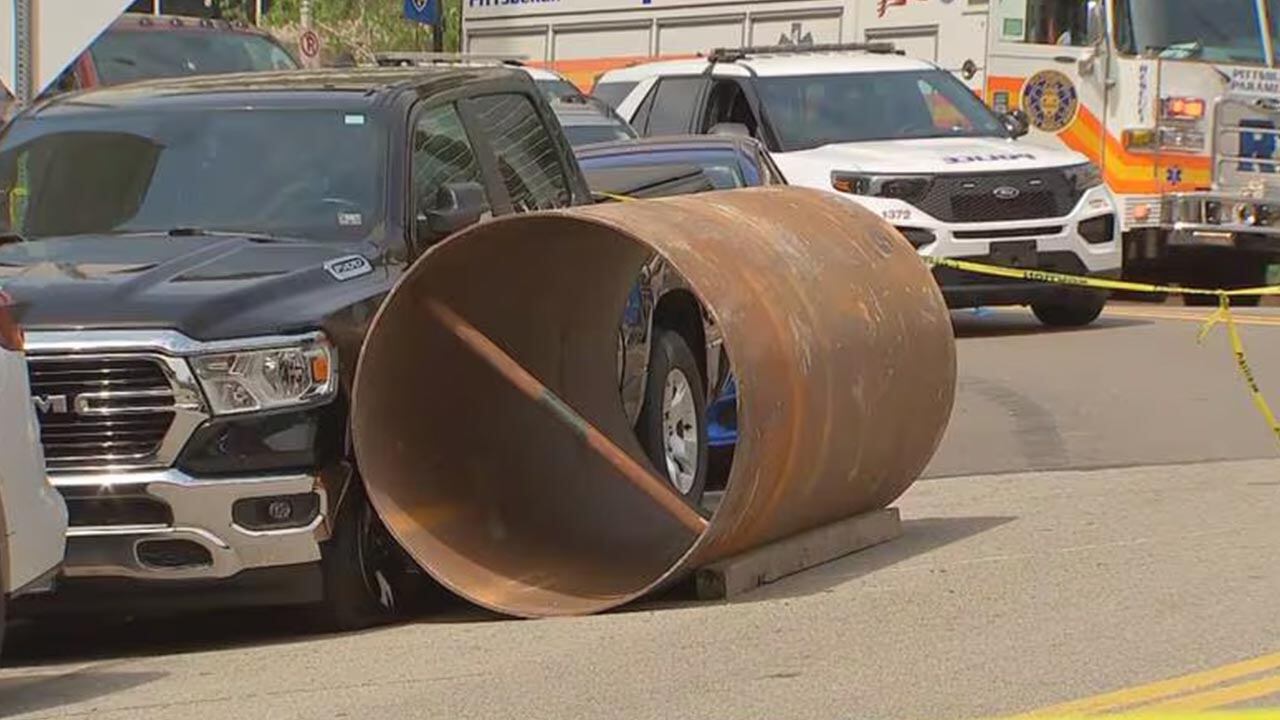 Metal cylinder resting against a pickup truck.