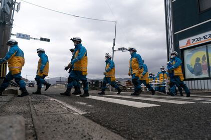 WAJIMA, JAPAN - JANUARY 05: Police officers cross a road as they search for survivors in the aftermath of an earthquake on New Year's Day on January 05, 2024 in Wajima, Japan. A series of major earthquakes have reportedly killed at least 92 people, injured dozens more and destroyed a large amount of homes. The earthquakes, the biggest measuring 7.1 magnitude, hit the areas around Ishikawa, Toyama and Niigata in central Japan on Monday. (Photo by Tomohiro Ohsumi/Getty Images)