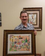 Art collector Mike Fowler poses with an original painting by artist Matthew Livsey.