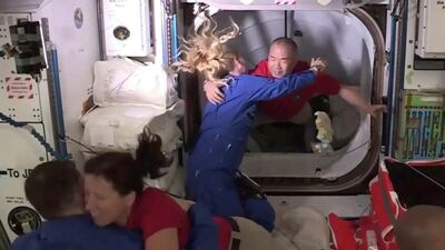 In this frame grab from NASA TV, astronaut Soichi Noguchi, background right, is greeted by astronaut Kate Rubins, as he enters the International Space Station from the vestibule between the SpaceX Dragon capsule and the ISS, early Tuesday, Nov. 17, 2020.