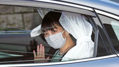 Japan's Princess Mako waves from a car as she leaves her home in Akasaka Estate in Tokyo Tuesday, Oct. 26, 2021. Mako and her commoner boyfriend Kei Komuro tied the knot Tuesday without wedding celebration in a marriage that has split the public opinion over her would-be mother-in-law's financial controversy.