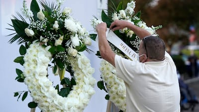 A man puts up a wreath before a candlelight vigil for the late cinematographer Halyna Hutchins, Sunday, Oct. 24, 2021, in Burbank, Calif. A prop firearm discharged last Thursday by actor Alec Baldwin, while producing and starring in a Western movie in Santa Fe, N.M., killed Hutchins and wounded director Joel Souza.