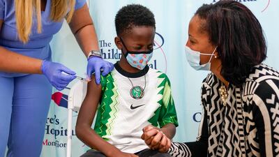 Dr. Rhonda Achonolu comforts her son Amechi, 7, as he is inoculated with first dose of the Pfizer-BioNTech COVID-19 vaccine for children 5 to 11 years old at The Children's Hospital at Montefiore, Wednesday, Nov. 3, 2021, in the Bronx borough of New York.