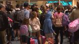 Crowds pass through Orlando International Airport during busy travel day